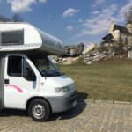Zdjęcie Kampera Fiat Ducato II Burstner stojącego na tle polskiego zamku