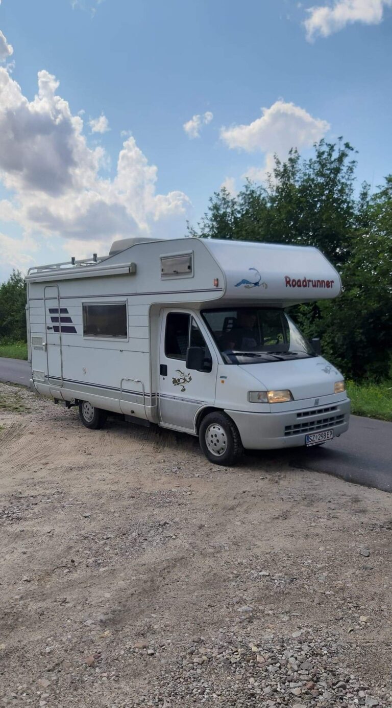 Przód kampera Fiat Ducato II Hymer Struś stojący na drodze w tle las