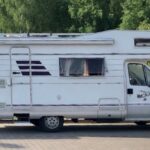 Bok kampera Fiat Ducato II Hymer Struś stojący na drodze w tle las