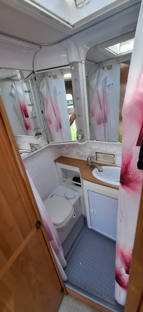 Wnętrze kampera na wynajem Hymer Żółwik łazienka, kabina, zlew, toaleta, lustro